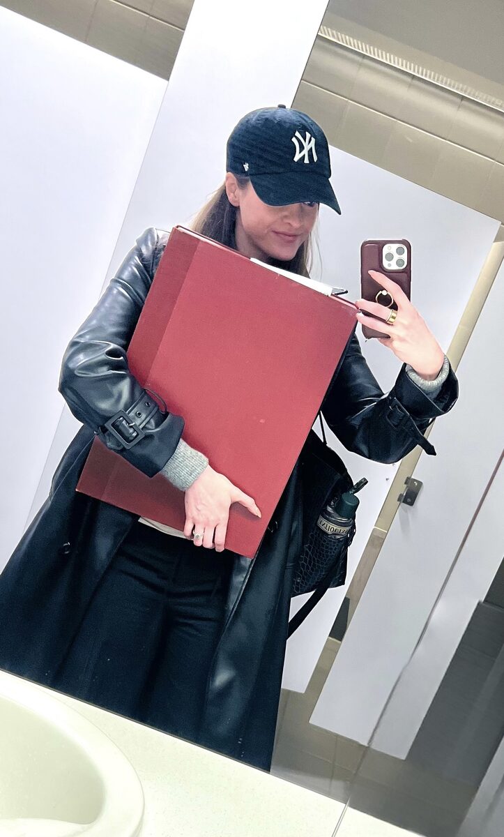 Holding a large red archaeological report in front of a mirror