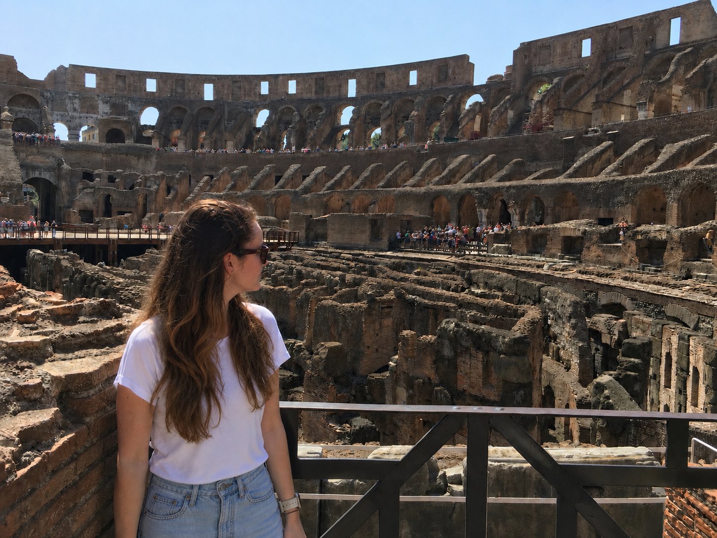 Kim standing at a railing inside the Colosseum in Rome, looking out over the arena and its excavated substructures